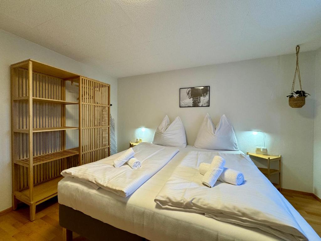 a bedroom with a large white bed with two pillows at Bauernchalet Alois in Dornbirn