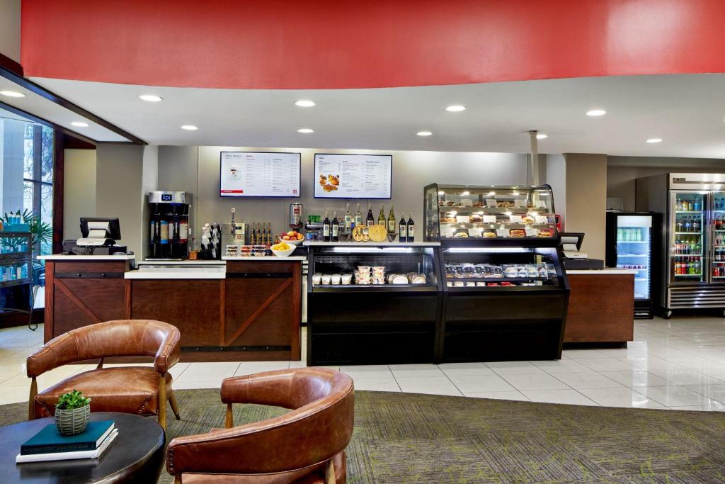 a restaurant with a counter and chairs and a bar at Renaissance Mobile Riverview Plaza Hotel in Mobile