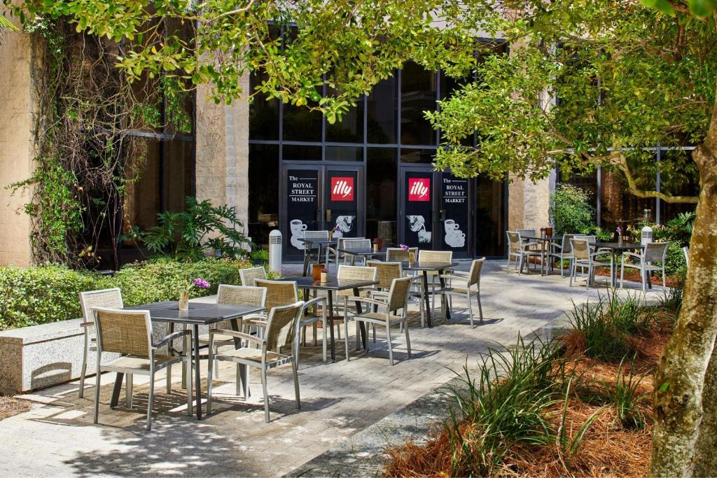 a group of tables and chairs in front of a building at Renaissance Mobile Riverview Plaza Hotel in Mobile
