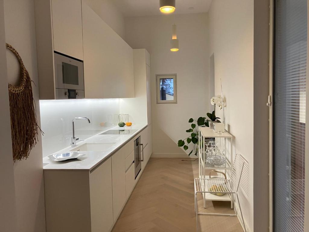 uma casa de banho branca com um lavatório e um balcão em Citylux Verdandi em Turku