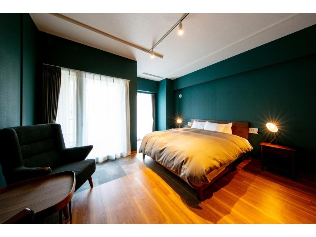 a bedroom with a bed and a chair and a window at VILLA KOSHIDO ODORI - Vacation STAY 04756v in Sapporo