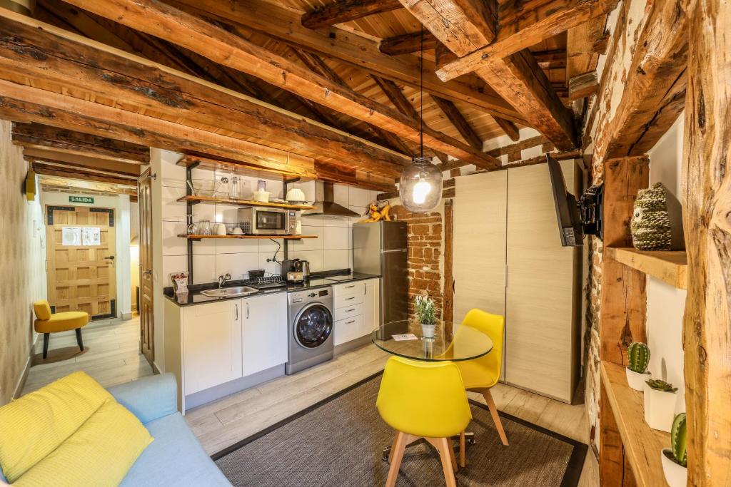 - une cuisine avec une table et des chaises jaunes dans la chambre dans l'établissement AP Plaza de España 12, à Madrid