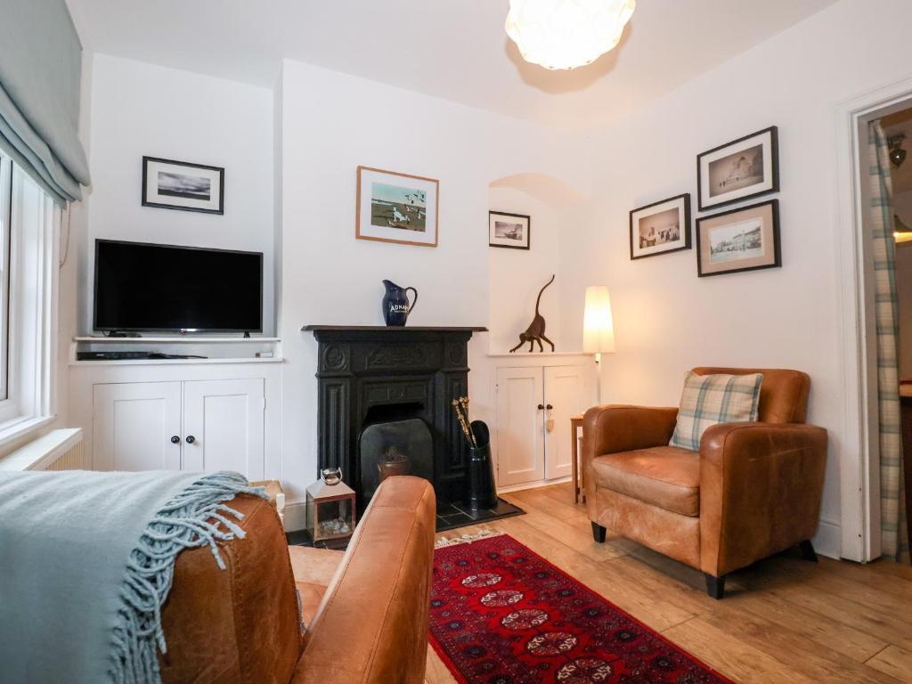 a living room with a fireplace and a television at Holmleigh, Aldeburgh in Aldeburgh