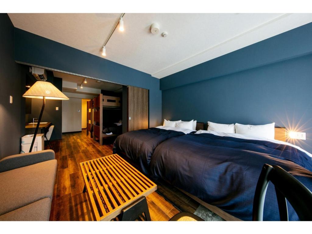 Habitación de hotel con cama y sofá en VILLA KOSHIDO ODORI - Vacation STAY 04752v, en Sapporo