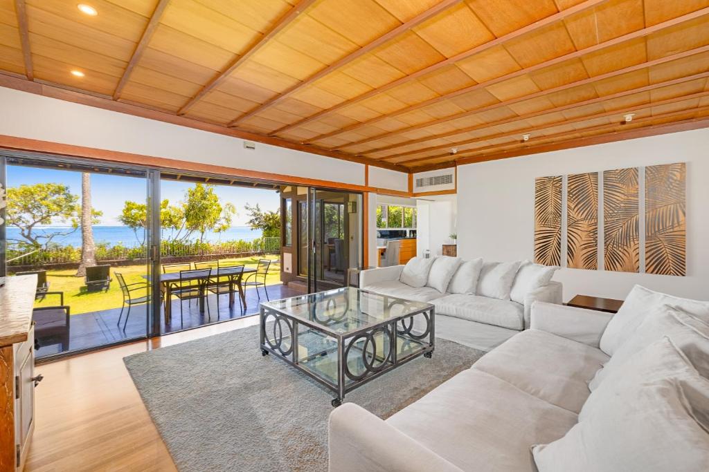 ein Wohnzimmer mit einem Sofa und einem Glastisch in der Unterkunft South Shore Paradise - 30-Night Minimum in Honolulu