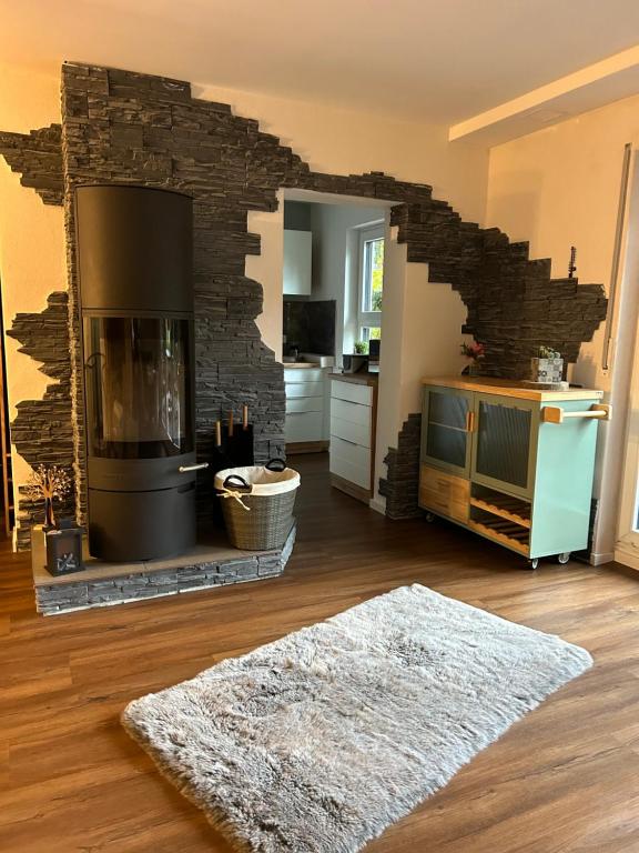 sala de estar con chimenea y alfombra en Haus mit Sauna am Waldrand - Nähe Brombachsee Altmühlsee, en Windsbach