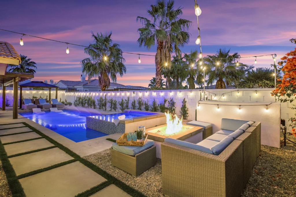 an image of a backyard with a swimming pool at night at THE Fun House FULL Arcade LUX backyard Sleeps 12 in Indio