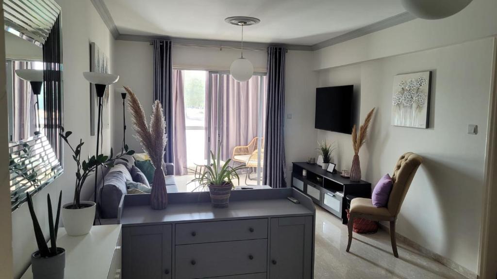 a living room with a couch and a window at Modern Cityscape Home in Nicosia