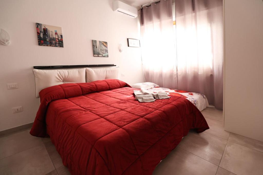 um quarto com uma cama vermelha e um cobertor vermelho em B&B Royal Palace of Napoli & Reggia di Caserta em Caserta