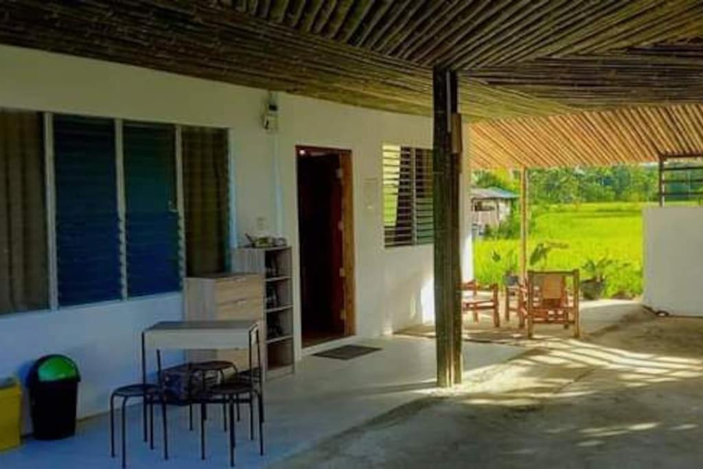 eine Terrasse mit Stühlen und einem Tisch in einem Haus in der Unterkunft Bamboo Garden Tourist Inn in Carmen