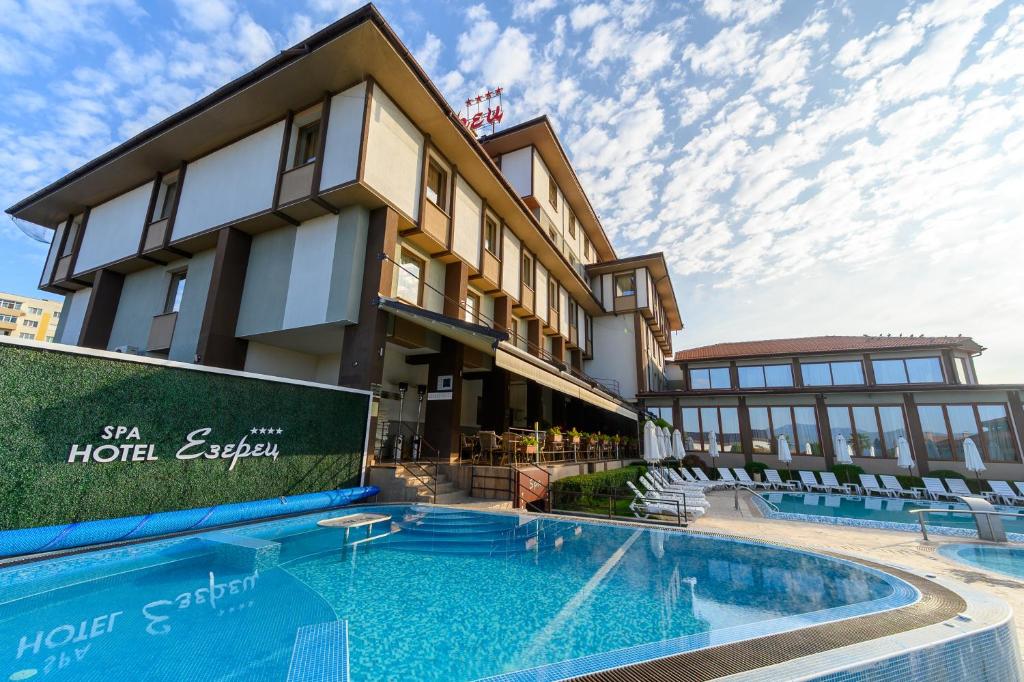 un hôtel avec une piscine en face d'un bâtiment dans l'établissement Spa Hotel Ezeretz Blagoevgrad, à Blagoevgrad