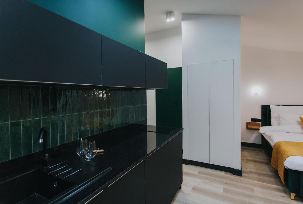 a bathroom with a black counter and a bed at Apartamenty BIBLIO in Łódź