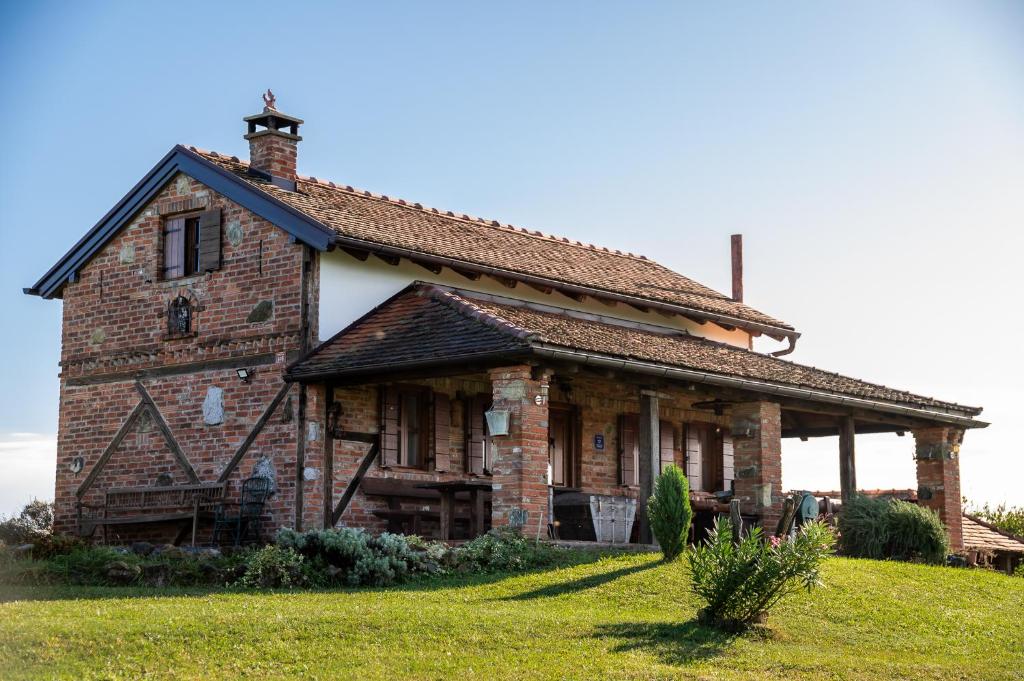 an old brick house on a grass field at Kuća sreće Veronika in Nova Gradiška