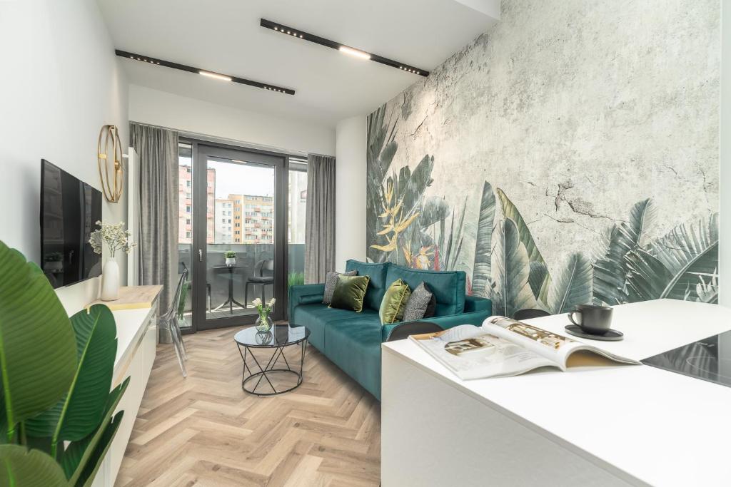 ein Wohnzimmer mit einem blauen Sofa und einem TV in der Unterkunft Comfy Apartments 4-5th Floor Hanza Tower - Sauna & Pool in Stettin