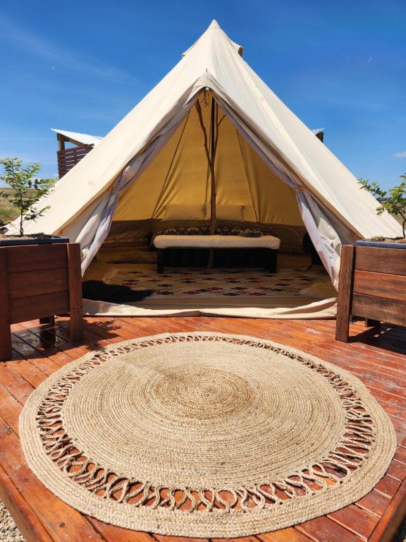 a tent with a rug on a wooden floor at Two Little Piggies Glamping 