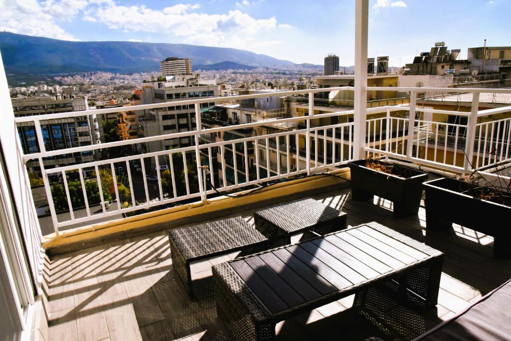 einen Balkon mit Bänken und Stadtblick in der Unterkunft Tiny rooftop apartment in Athen