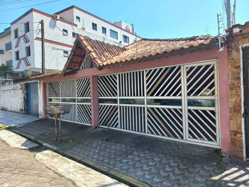 a building with a garage with a fence at BRILHO DO SOL II in Praia Grande