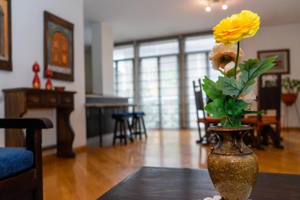 a vase with a yellow flower on a table at Colonial Charm. Experience historic Quito. in Quito
