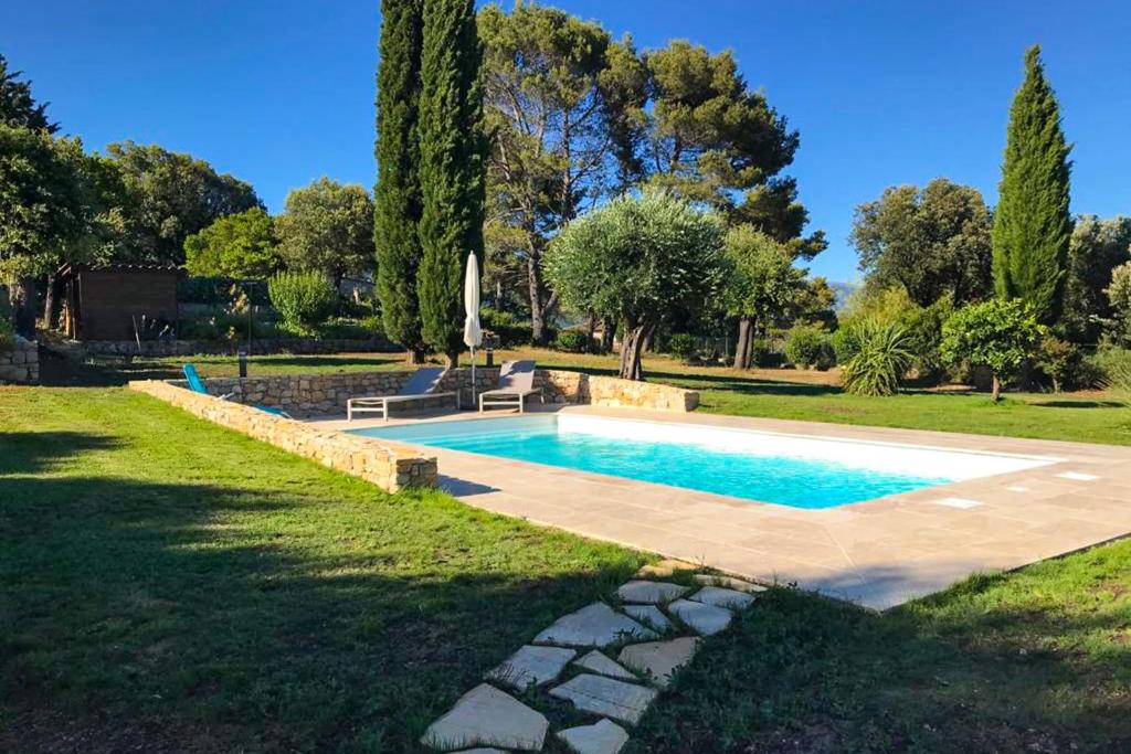 a swimming pool in a yard with a grass field at Villa with swimming pool for 6 people in Peymeinade near Cannes in Peymeinade