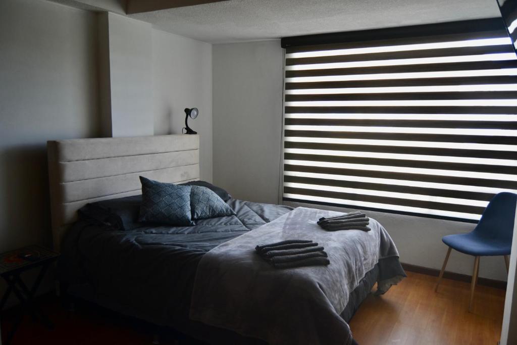 a bedroom with a bed and a large window at SLH Boutique Guesthouse in Pasto