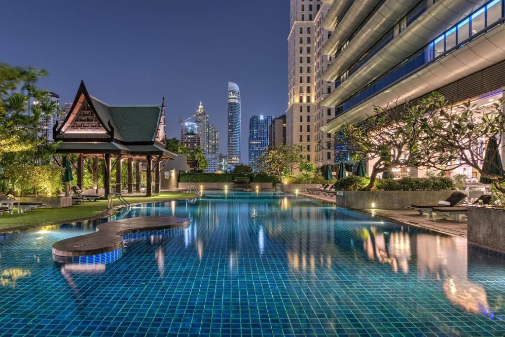 een zwembad met een skyline van de stad op de achtergrond bij The Athenee Hotel, a Luxury Collection Hotel, Bangkok in Bangkok