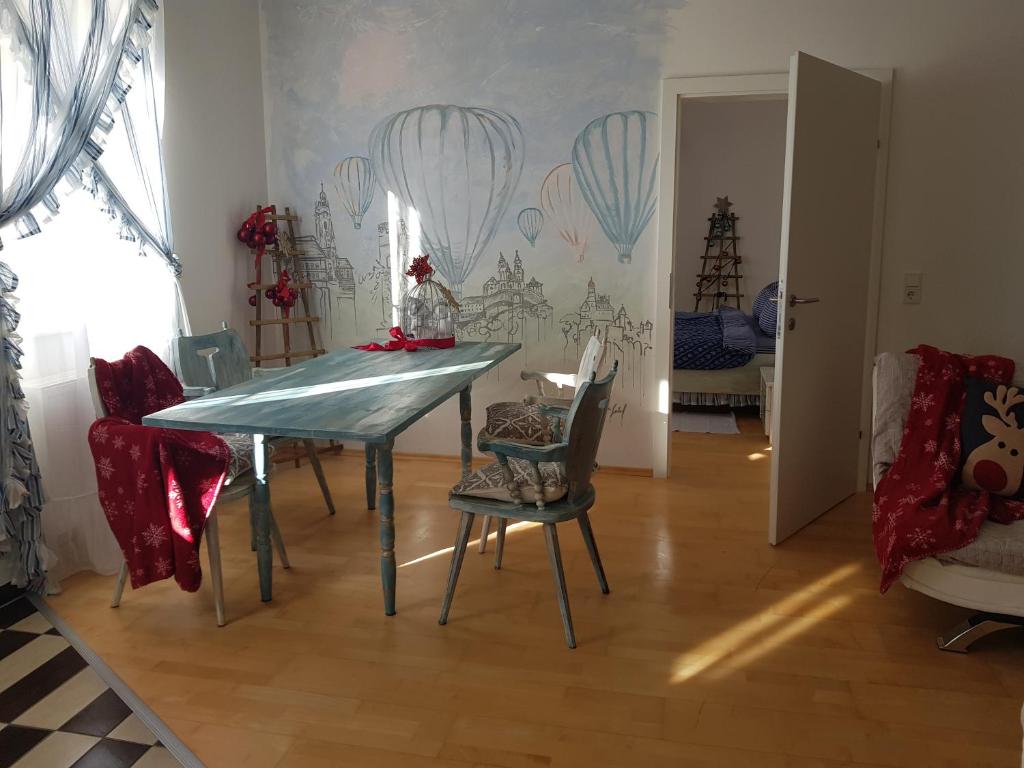 a dining room with a blue table and chairs at Kunst Apartment im Schwalbenhaus in Spitz