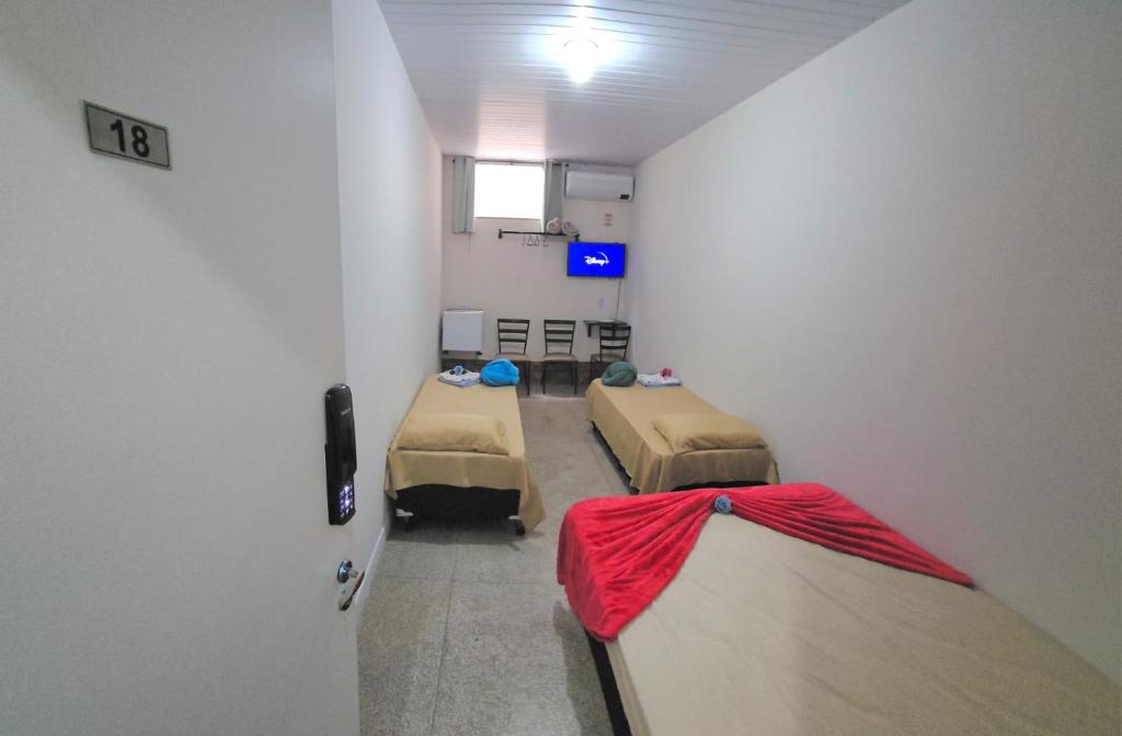 a hospital room with two beds and a tv at Pousada Aqua in Campo Grande