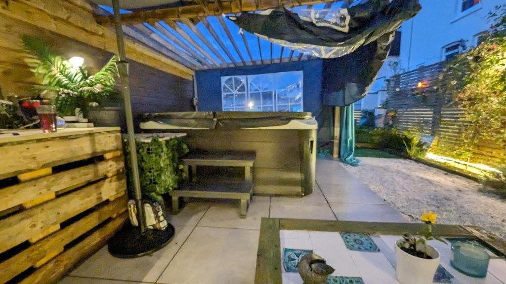 a patio with a grill and a table and some plants at Upstairs Downstairs Regency Apartments in Cheltenham