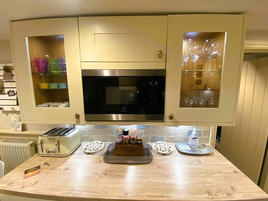 a kitchen with a counter top with a microwave at Luxury Coastal Cottage with free parking - 5 mins walk to town & beach in Aldeburgh