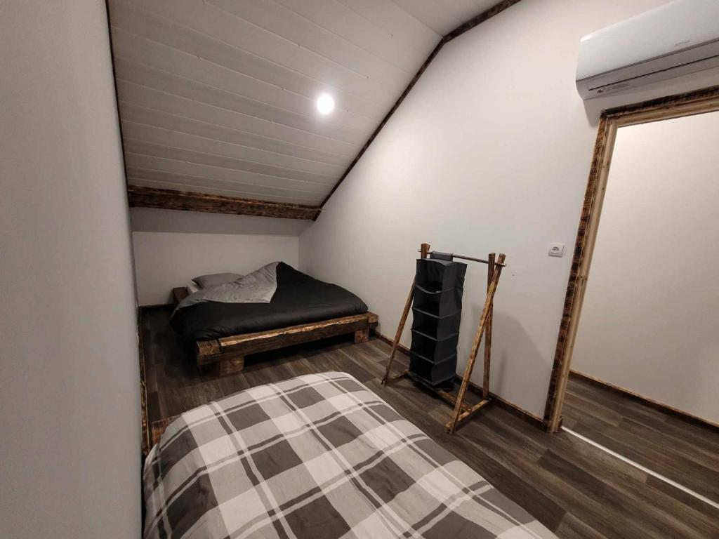 a attic room with a bed and a mirror at Gîte de la Ferme de la Comté in Le Thillot