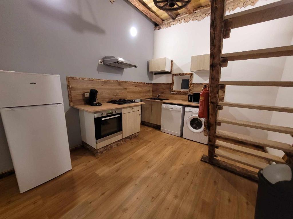 a kitchen with white appliances and a wooden floor at Gîte de la Ferme de la Comté in Le Thillot