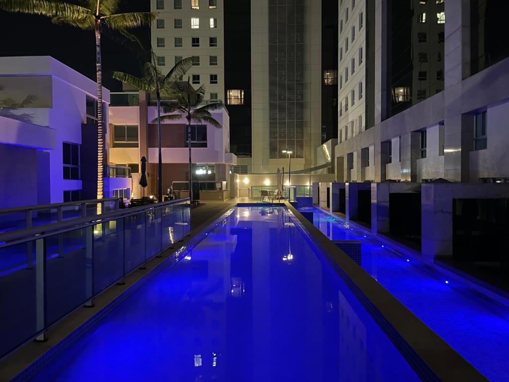 a large swimming pool in a city at night at Flat Jade Hotel Brasília in Brasilia