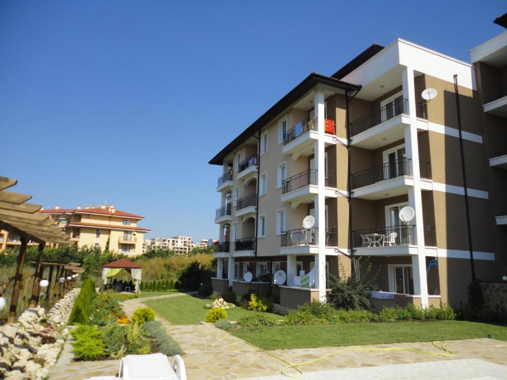 a large apartment building with a patio and a yard at Domus Extra Apartments in Sveti Vlas