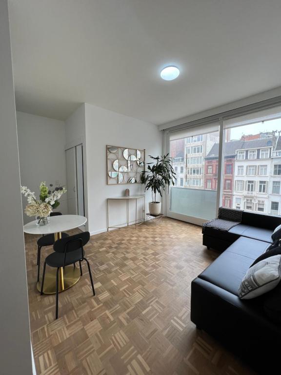 a living room with a couch and a table at Beautiful new apartment Antwerpen in Antwerp