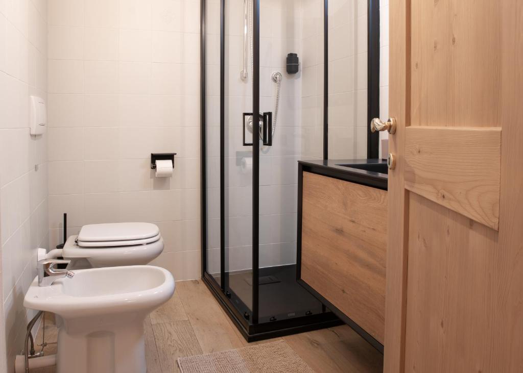 a bathroom with a toilet and a glass shower at Guvi’sHome Bormio in Bormio