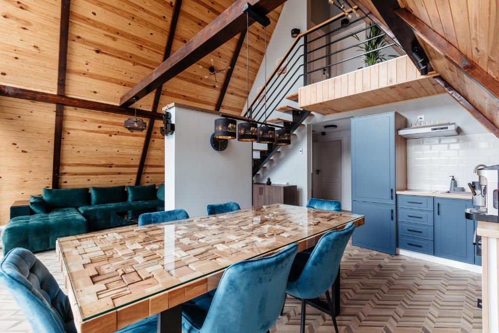 ルメテアにあるKARL's Cabin by Black & White Panoramicのキッチン、ダイニングルーム(大きな木製テーブル、青い椅子付)