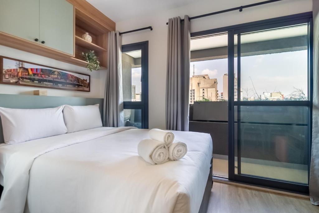 360 Pamplona في ساو باولو: غرفة نوم بسرير أبيض مع نافذة كبيرة