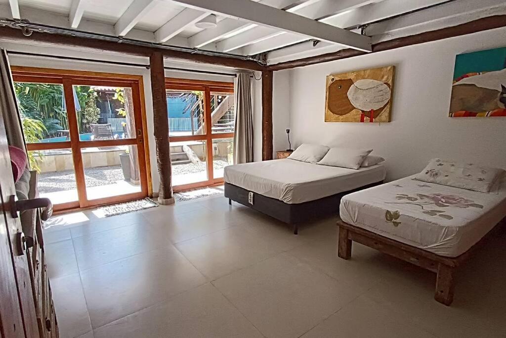a bedroom with two beds and a window at Refugio e Conforto: Mata/Hidro/Área Gourmet/Wifi in São Sebastião