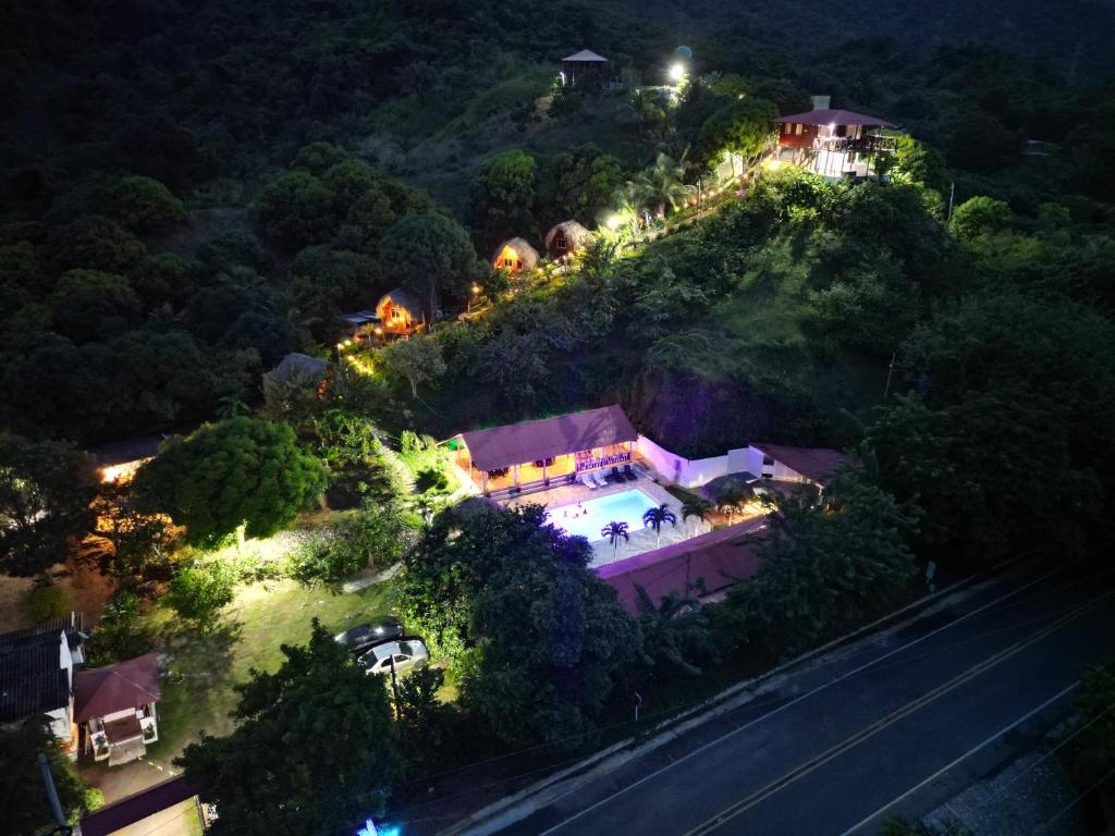 een huis aan de zijkant van een heuvel 's nachts bij Cabañas Orlando y Más Na' Tayrona in El Zaino