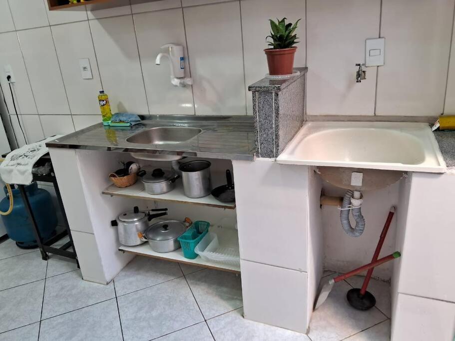 uma cozinha com um lavatório e uma bancada em kitnet em São João Del Rei, a 11km de Tiradentes MG em São João del Rei