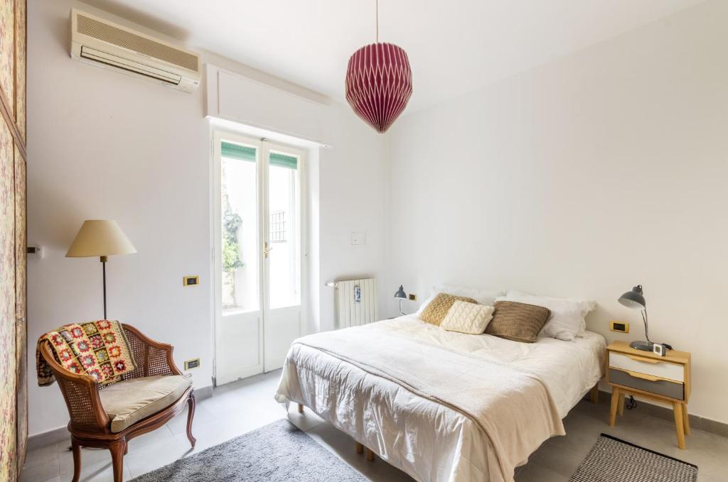 ローマにあるMonteverde lovely flatの白いベッドルーム(ベッド1台、椅子付)