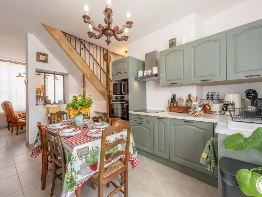 a kitchen with green cabinets and a table with chairs at Gîte Nourard-le-Franc, 5 pièces, 6 personnes - FR-1-526-44 in Ravenel