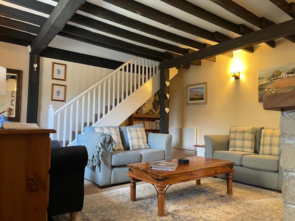 Chideock的住宿－Gingerbread Cottage，客厅配有两张沙发和一张桌子