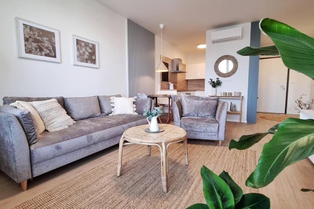 ein Wohnzimmer mit einem Sofa und einem Tisch in der Unterkunft 10 Minutes to City: Cozy Urban Apartment Stay in Bratislava