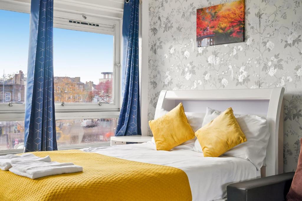 a bedroom with a bed with yellow sheets and a window at Impeccable 1-Bed Apartment in London in London