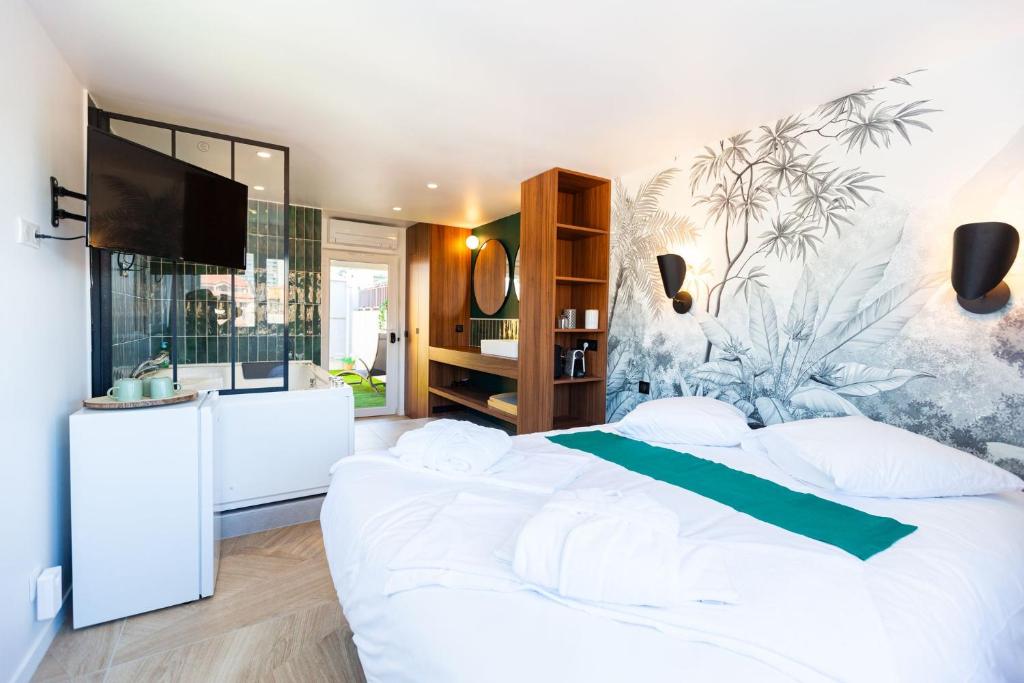 a bedroom with a large white bed and a tv at Love Room du Mont d'Or in Marseille