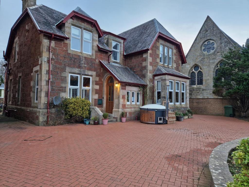 a large brick house with a brick driveway at The Old Rectory in Largs