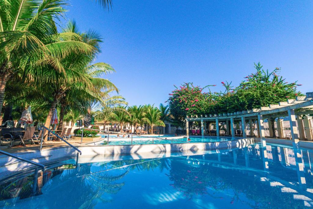 una piscina con palmeras y un edificio en Lacqua Diroma Apartment, en Caldas Novas