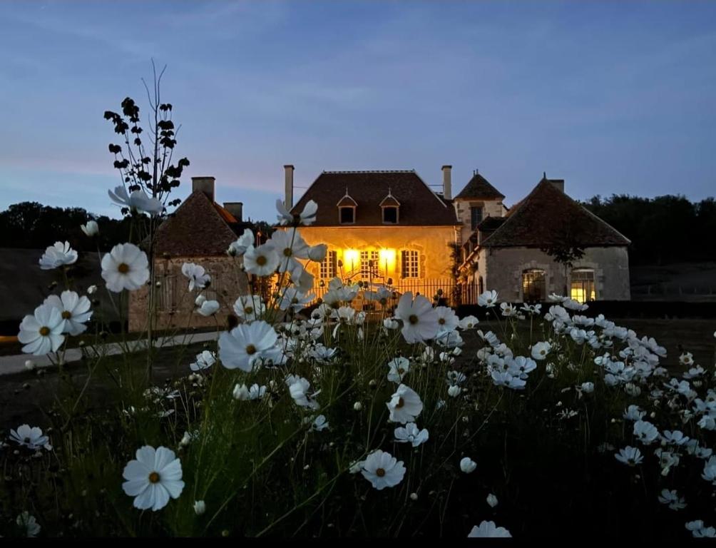 un campo de flores blancas delante de una casa en Château de Paraize, en Livry