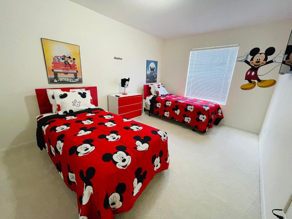 a bedroom with two beds with black and white mickey beds at Home in davenport Cheerful 5-bedroom with private Pool close to Disney in Davenport